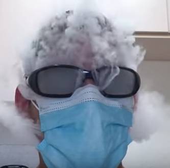Bild av man som blåser ut rök från en e-cigarett i en kirurgmask